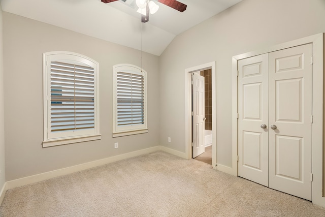 unfurnished bedroom with lofted ceiling, carpet flooring, connected bathroom, ceiling fan, and baseboards