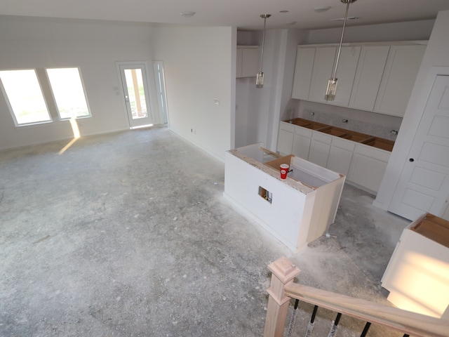 8622 Pier Cove Dr, Cypress, TX 77433 - kitchen with a kitchen island, white cabinets, pendant lighting, and concrete flooring