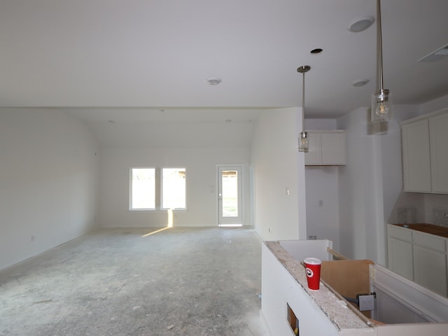 8622 Pier Cove Dr, Cypress, TX 77433 - kitchen with white cabinetry, decorative light fixtures, and concrete flooring