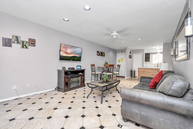 living room with baseboards, ceiling fan, light floors, a fireplace, and recessed lighting