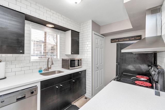 kitchen with light countertops, decorative backsplash, appliances with stainless steel finishes, a sink, and extractor fan