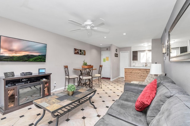 living area featuring light floors, baseboards, a ceiling fan, and recessed lighting