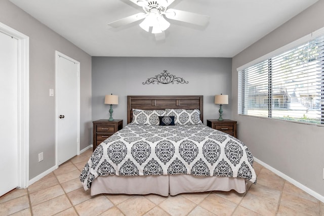 bedroom with ceiling fan, light tile patterned flooring, and baseboards