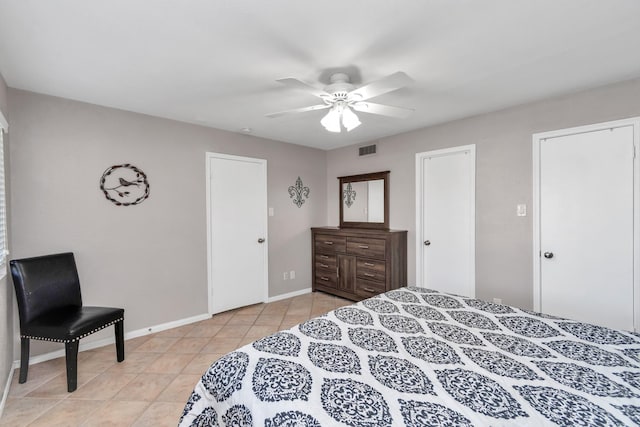 bedroom with a ceiling fan, visible vents, baseboards, and light tile patterned floors