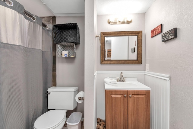 bathroom featuring toilet, curtained shower, and vanity