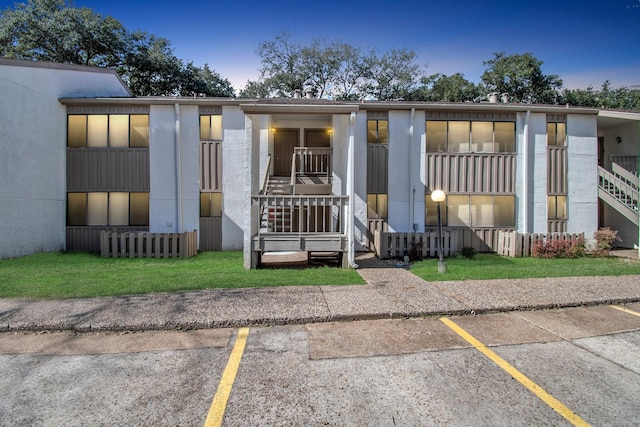 townhome / multi-family property featuring uncovered parking, a front yard, and stairway