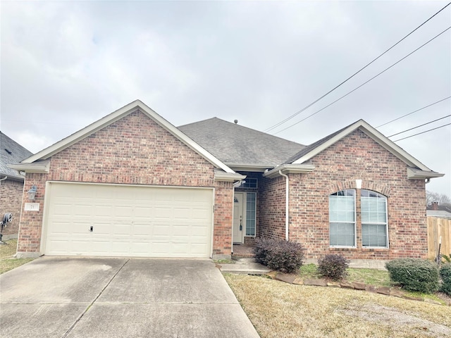 ranch-style home featuring a shingled roof, concrete driveway, brick siding, and an attached garage