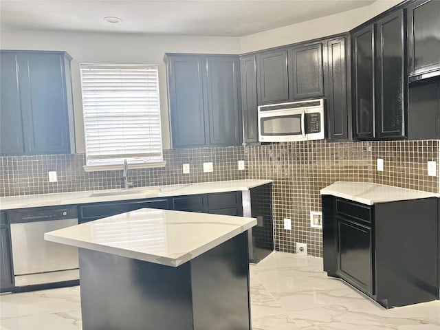 kitchen with tasteful backsplash, appliances with stainless steel finishes, marble finish floor, light countertops, and a sink