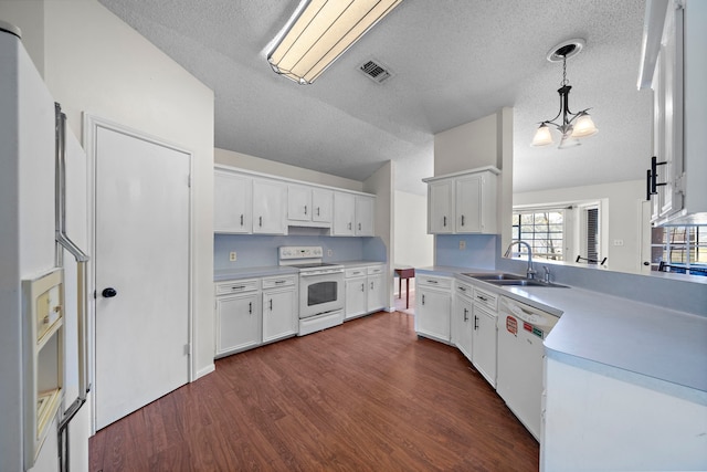 kitchen with white appliances, visible vents, dark wood-style floors, light countertops, and a sink