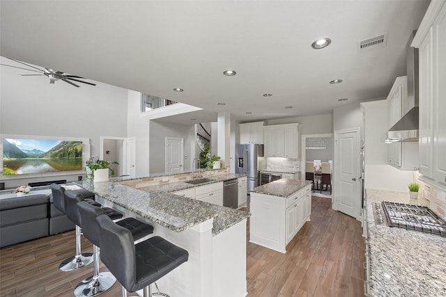 kitchen featuring visible vents, a spacious island, appliances with stainless steel finishes, open floor plan, and light wood-type flooring