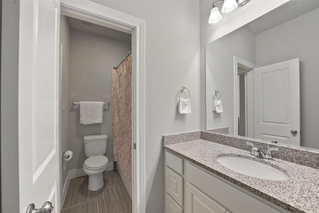 full bathroom with tile patterned flooring, baseboards, vanity, and toilet