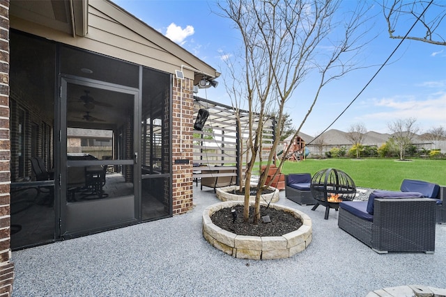 view of patio / terrace with a fire pit and a sunroom