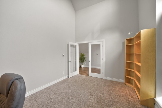 unfurnished room with carpet floors, french doors, high vaulted ceiling, and baseboards