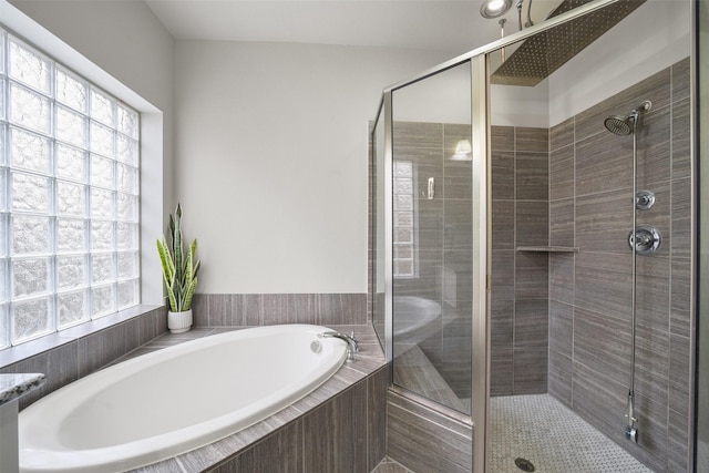 bathroom featuring a stall shower, plenty of natural light, and a bath