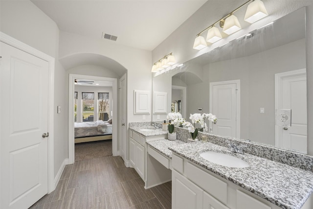 full bath with visible vents, a ceiling fan, vanity, ensuite bath, and baseboards