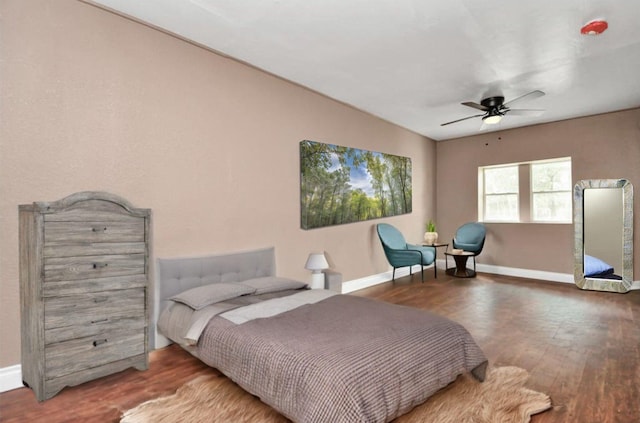 bedroom with wood finished floors, a ceiling fan, and baseboards