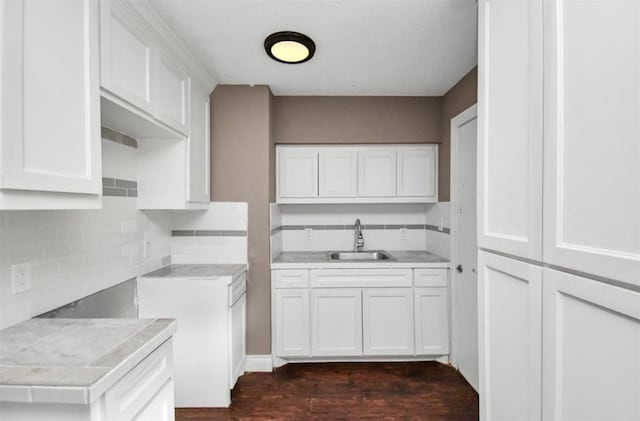 kitchen with light countertops, a sink, and backsplash