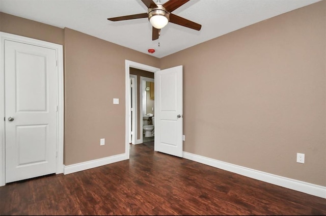 unfurnished bedroom with ceiling fan, baseboards, and dark wood-style flooring