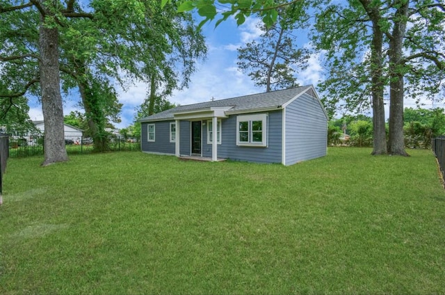 back of house with a lawn and a fenced backyard