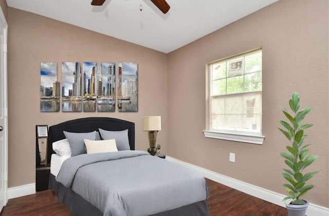 bedroom featuring ceiling fan, dark wood-type flooring, baseboards, vaulted ceiling, and a view of city