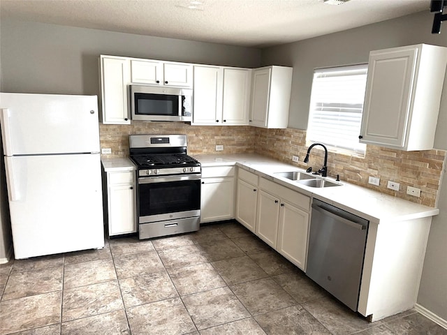 kitchen featuring white cabinetry, stainless steel appliances, light countertops, and a sink