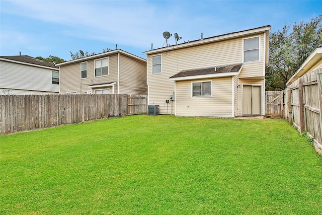 rear view of property with a fenced backyard, a lawn, and central AC unit