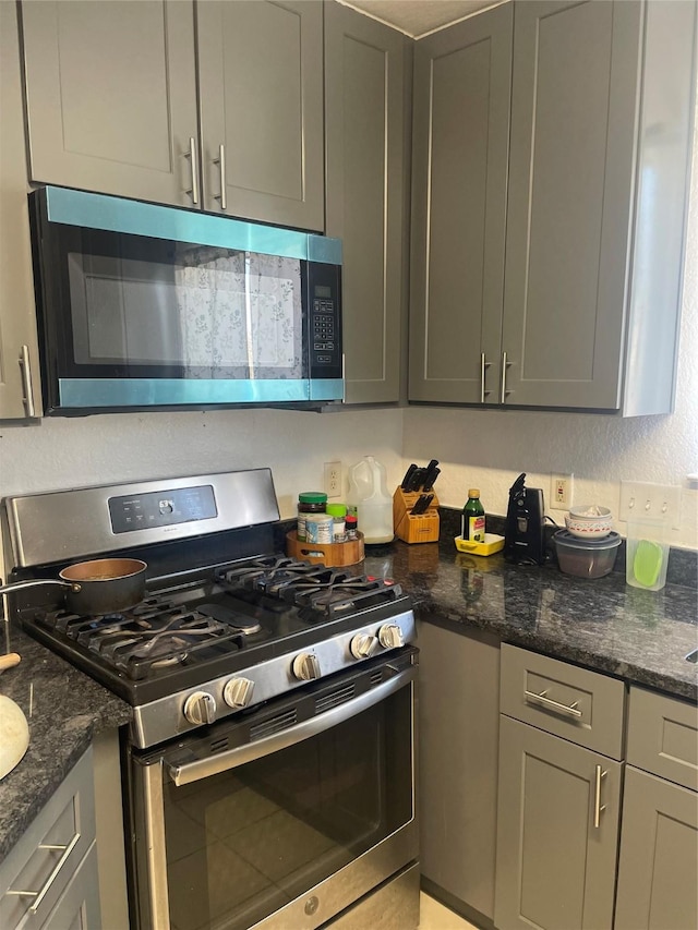 kitchen with dark stone counters and stainless steel appliances