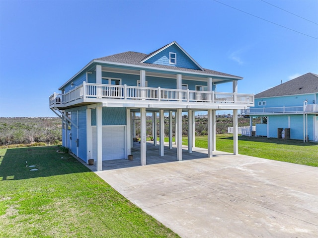 beach home featuring driveway, a carport, a front yard, and a shingled roof