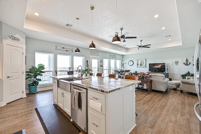 kitchen with light wood-style flooring, a sink, white cabinetry, dishwasher, and a raised ceiling