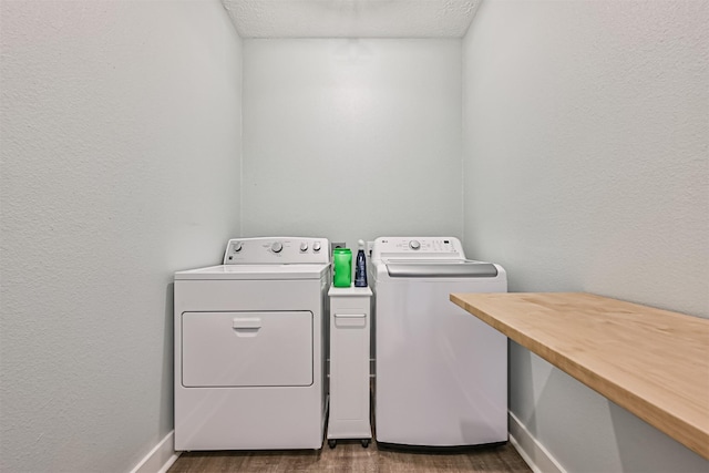 laundry area featuring laundry area, baseboards, dark wood-style flooring, and washing machine and clothes dryer