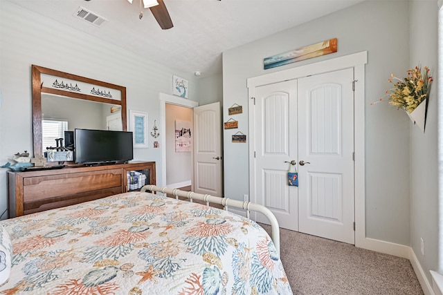 carpeted bedroom featuring a ceiling fan, a closet, visible vents, and baseboards