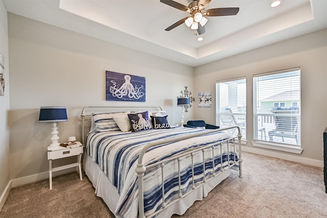 bedroom featuring carpet floors, a tray ceiling, baseboards, and recessed lighting