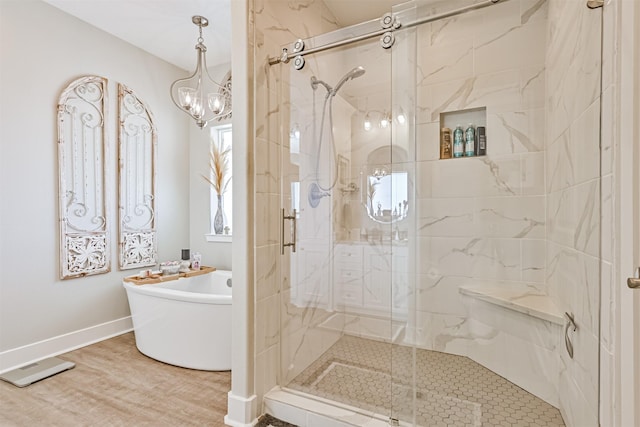 full bathroom with baseboards, a freestanding bath, a marble finish shower, and wood finished floors