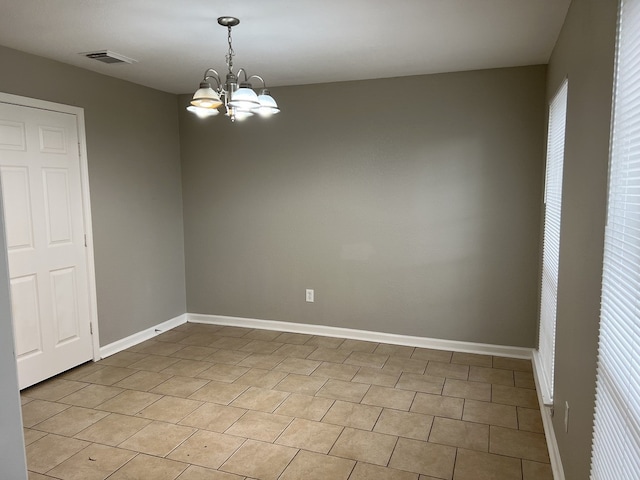 unfurnished room featuring baseboards, visible vents, and a notable chandelier