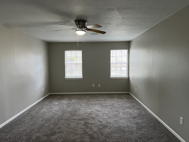 carpeted empty room featuring a healthy amount of sunlight, baseboards, and a textured ceiling