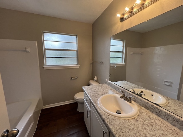 bathroom with shower / bath combination, baseboards, toilet, wood finished floors, and vanity