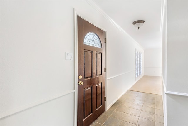 entryway featuring crown molding, baseboards, a wealth of natural light, and tile patterned floors