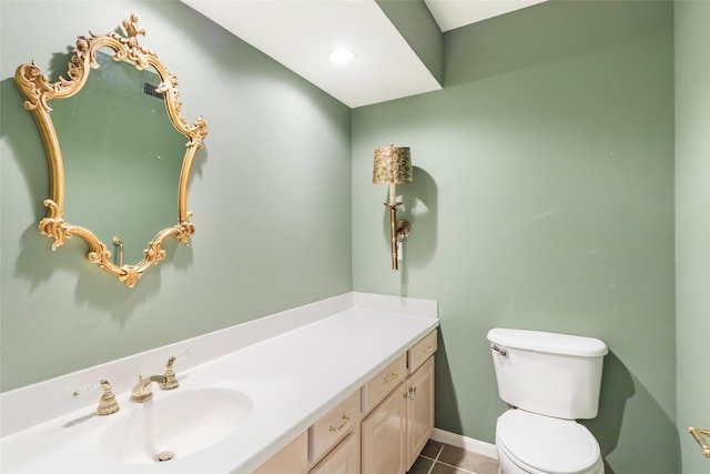 half bathroom featuring tile patterned flooring, vanity, and toilet