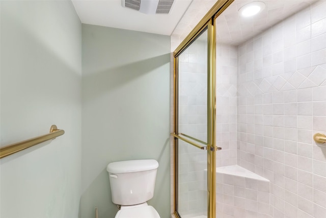 bathroom with toilet, a shower stall, and visible vents