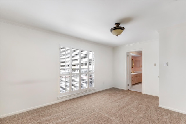 empty room with light carpet, baseboards, and crown molding