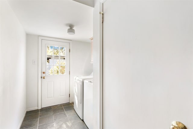 washroom with laundry area, washing machine and dryer, and baseboards