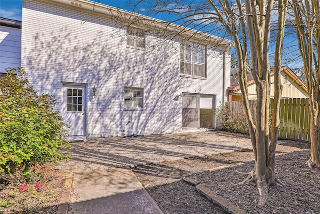 view of home's exterior with brick siding and fence