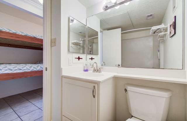 full bath with visible vents, toilet, vanity, a textured ceiling, and tile patterned flooring