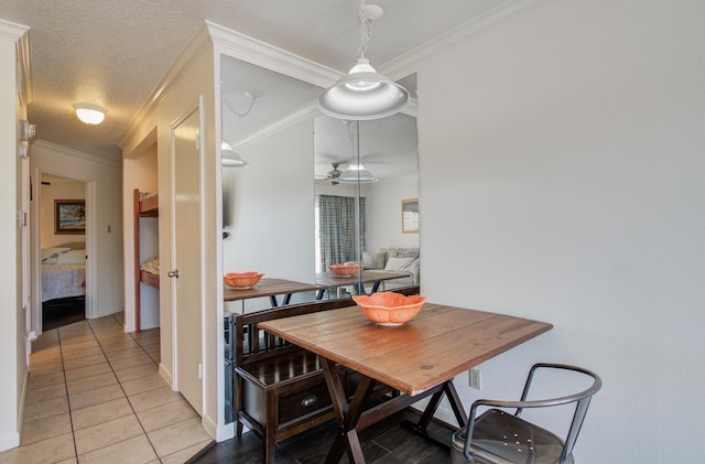 dining area with ornamental molding, a textured ceiling, and light tile patterned floors