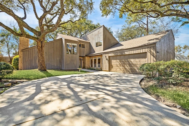 view of front of house featuring driveway, a shingled roof, and an attached garage