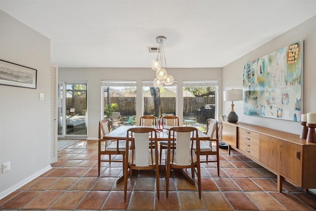 dining room with dark tile patterned floors, baseboards, and visible vents