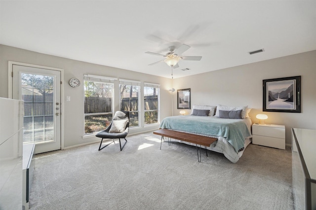 carpeted bedroom featuring access to exterior, baseboards, visible vents, and a ceiling fan