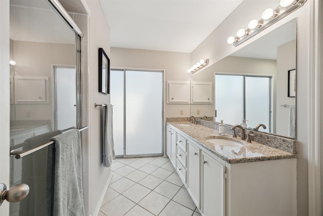 bathroom featuring double vanity, a sink, a shower stall, and tile patterned floors