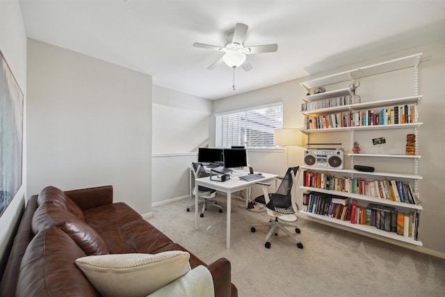 office area with carpet, a ceiling fan, and baseboards