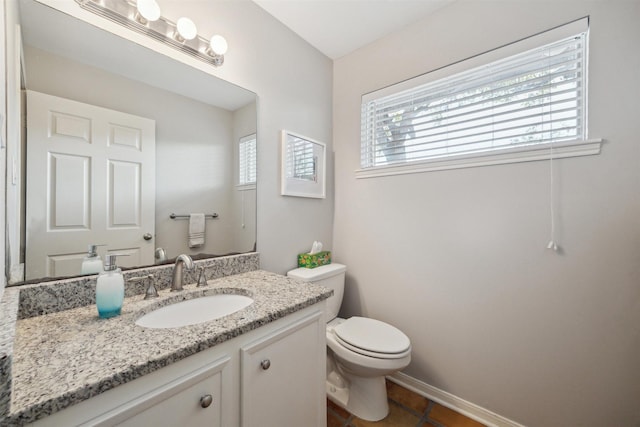 half bathroom with a healthy amount of sunlight, vanity, and toilet